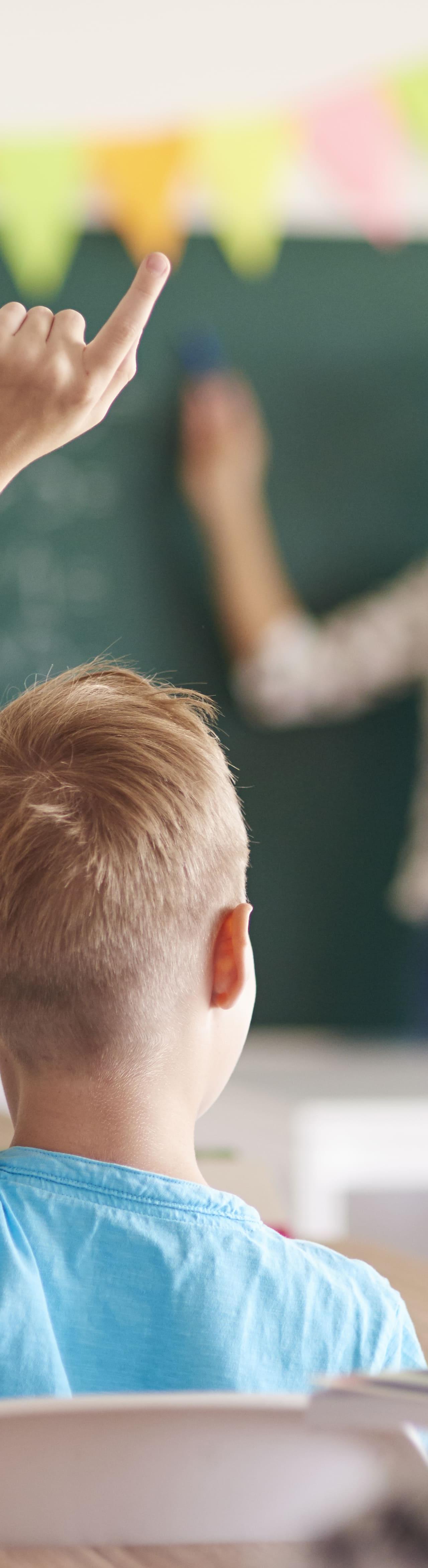 Des élèves en classe lèvent la main pour participer